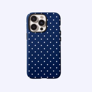 May include: A navy blue phone case with a white polka dot pattern. The case has a protective design and features a camera cutout. The phone case is designed to fit a smartphone.