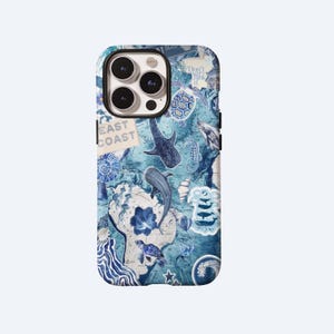 Puede incluir: Una funda de teléfono con un diseño azul y blanco con temática oceánica. La funda presenta ilustraciones de vida marina, incluyendo tiburones, tortugas y un mapa. Las palabras "East Coast" son visibles en un pequeño letrero.