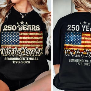 May include: Black t-shirt featuring a distressed American flag design with the text "250 YEARS" and "We the People." The shirt commemorates the semiquincentennial, spanning from 1776 to 2026. The design includes stars and stripes.