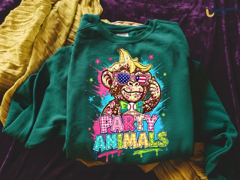 Puede incluir: Sudadera verde oscuro con un mono de dibujos animados con gafas de sol con un dise&ntilde;o de bandera estadounidense y un pl&aacute;tano en la cabeza. El texto "PARTY ANIMALS" se muestra en letras coloridas estilo grafiti.