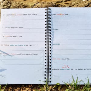 Puede incluir: Diario abierto con p&aacute;ginas rayadas y encuadernaci&oacute;n en espiral. Las indicaciones del diario incluyen "Mi recuerdo m&aacute;s especial de este viaje es", "Me re&iacute; m&aacute;s cuando" y "Estoy agradecido por".