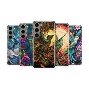 May include: A collection of phone cases with vibrant, artistic designs. Each case features a unique illustration of hummingbirds and floral elements in a variety of colors, including blue, green, red, and gold. The cases are displayed against a white background.