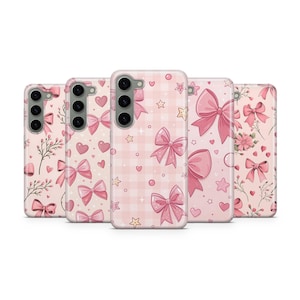 May include: A collection of pink phone cases with various patterns. Designs include bows, hearts, stars, and floral elements. The cases are arranged in a row, showcasing different styles and textures.
