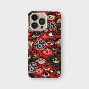 May include: A phone case with a repeating pattern of stylized eyes in red, black, and white. The design includes various eye shapes and sizes, creating a complex and artistic aesthetic. The case has a glossy finish.