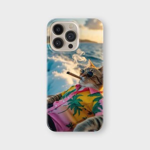 May include: A phone case featuring a cat wearing sunglasses and a Hawaiian shirt, smoking a cigar. The shirt is pink and yellow with a palm tree design. The background shows a seascape with a sunset.