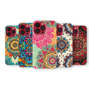 May include: A selection of phone cases displaying detailed mandala patterns in a range of colours. The cases feature teal, pink, orange, and red hues, with floral and geometric designs. The cases are arranged in a row, showcasing their unique designs.