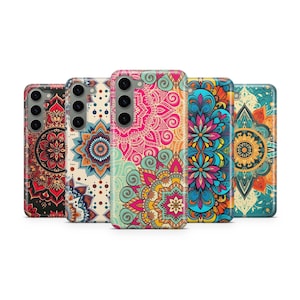 Puede incluir: Una colección de cinco fundas para teléfono con intrincados diseños de mandala. Las fundas presentan una variedad de colores, incluyendo rojo, rosa, azul y turquesa, con patrones detallados. Cada funda tiene un recorte para la cámara.