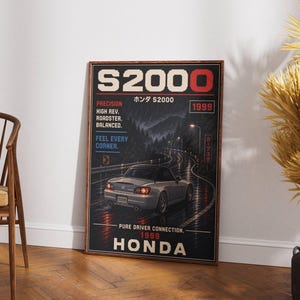 Pode incluir: Um poster emoldurado com um carro desportivo Honda S2000 prateado a conduzir numa estrada molhada à noite. O poster tem o texto "S2000" e "HONDA" numa fonte pixelizada, juntamente com outro texto, incluindo "PRECISION" e "1999". O fundo mostra uma paisagem montanhosa.