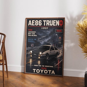 Könnte beinhalten: Ein gerahmtes Poster mit einem schwarz-weißen Toyota AE86 Trueno-Auto, das nachts auf einer nassen Straße fährt. Das Poster enthält den Text "AE86 TRUENO", "1986" und "TOYOTA". Zusätzlicher Text umfasst "TOUGE", "LIGHTWEIGHT", "DRIFT ICON" und "PURE BALANCE".