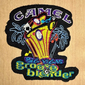 May include: Black embroidered patch with the word "CAMEL" in purple and white. The patch features a yellow and red design with the words "BIG VEGAS groove blender" in blue and yellow. The design includes palm trees and musical notes.