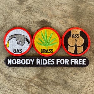 May include: Embroidered patches with humorous designs. One patch features a gas pump with the word "GAS", another a cannabis leaf with "GRASS", and a third a butt with "ASS". A rectangular patch below reads "NOBODY RIDES FOR FREE".