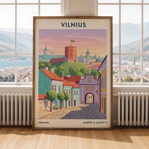 Può includere: Un poster di viaggio incorniciato di Vilnius, Lituania, con un'illustrazione colorata dello skyline della città, della Torre di Gediminas e di strade acciottolate. Il testo VILNIUS, Lithuania e le coordinate 54.6872° N, 25.2797° E sono stampati.