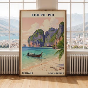 May include: A framed travel poster featuring a landscape illustration of Koh Phi Phi, Thailand. The artwork depicts a long-tail boat on turquoise water, sandy shores, and limestone cliffs under a soft sky. Text reads Koh Phi Phi, Thailand, 7.7441 N, 98.7775 E.