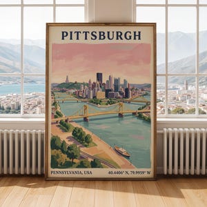 May include: A framed wall art print featuring a stylised illustration of the Pittsburgh skyline with the text PITTSBURGH at the top and PENNSYLVANIA, USA 40.4406 N, 79.9959 W at the bottom, showcasing yellow bridges over a river and a boat.