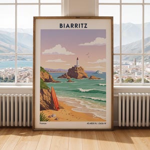 Può includere: Un poster di viaggio incorniciato di Biarritz, Francia, con un faro su uno scoglio, una spiaggia sabbiosa con una tavola da surf rossa e onde del mare. Il testo riporta BIARRITZ in alto e France 43.4830 N, 1.5636 W in basso in blu scuro.