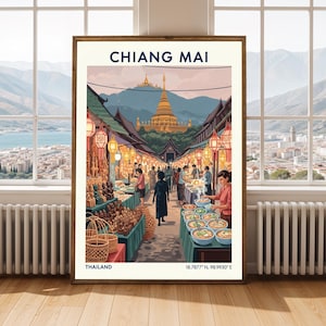May include: A framed art print showing a colourful illustration of Chiang Mai, Thailand. The artwork depicts a busy market scene with vendors, lanterns, and a golden temple in the background. The print includes the text "CHIANG MAI", "THAILAND", and coordinates.
