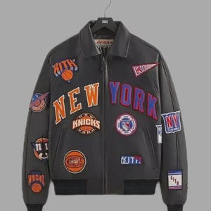 May include: A black leather jacket with multiple patches featuring the words "NEW YORK" and "KNICKS" in orange and blue. The jacket has a zip closure and a collar. The brand "KITH" is visible on some patches.
