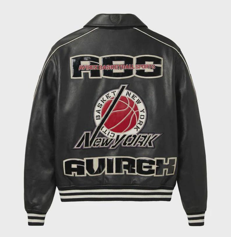 Puede incluir: Una chaqueta universitaria de cuero negro con parches bordados en blanco y rojo en la espalda. El dise&ntilde;o incluye el texto ABS, AVIREX BASKETBALL SPORTS, NEW YORK y AVIREX, junto con un gr&aacute;fico central de un bal&oacute;n de baloncesto rojo y una l&iacute;nea diagonal.