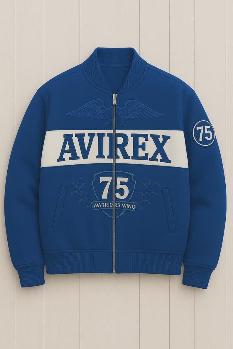 K&ouml;nnte beinhalten: Blaue Bomberjacke mit wei&szlig;em Bruststreifen. Die Jacke zeigt "AVIREX", die Zahl "75" und "WARRIORS WING". Sie hat einen durchgehenden Rei&szlig;verschluss und gerippte B&uuml;ndchen. Ma&szlig;e in Zentimetern.