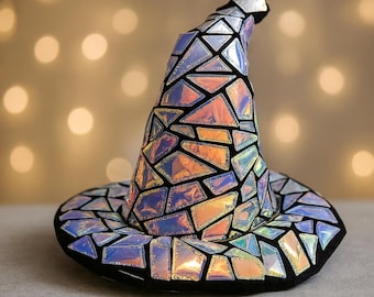 May include: A whimsical witch hat with a mosaic design. The hat features iridescent, geometric shapes in shades of orange, blue, and silver, outlined with black. The brim and the tip of the hat are also black.