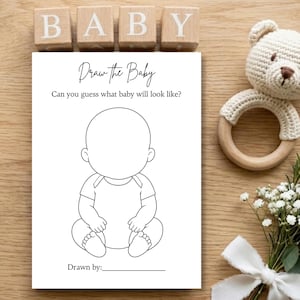 Può includere: Un biglietto per il gioco del baby shower con la scritta "Draw the Baby" e un contorno di bambino vuoto per disegnare. Blocchi di legno con la scritta "BABY" sopra la carta. Un sonaglio a forma di orso all'uncinetto e fiori con un nastro bianco sono anche nell'immagine.