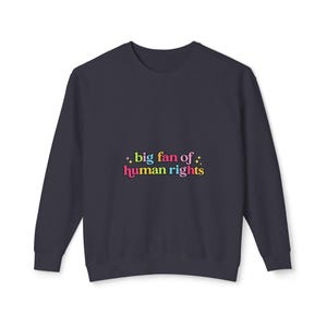 May include: Navy blue sweatshirt with the text "big fan of human rights" in colorful bubble letters. The text is accented with small starbursts. The sweatshirt is a solid color and has a crew neck.