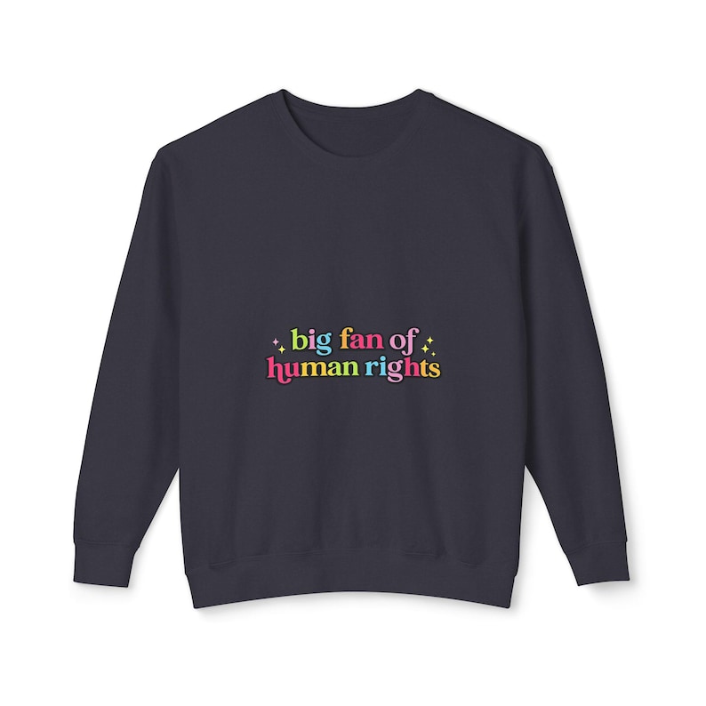 May include: Navy blue sweatshirt with the text "big fan of human rights" in colorful bubble letters. The text is accented with small starbursts. The sweatshirt is a solid color and has a crew neck.