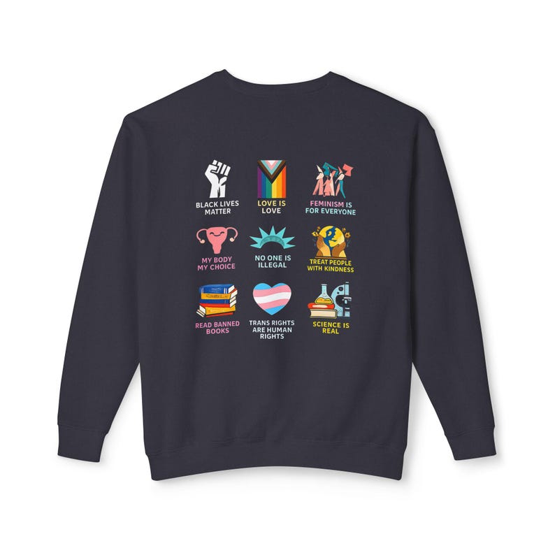 May include: Navy blue sweatshirt with nine colorful graphic designs. The designs include a raised fist, a rainbow flag, and the text "BLACK LIVES MATTER", "LOVE IS LOVE", and "FEMINISM IS FOR EVERYONE".