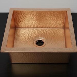 Könnte beinhalten: Ein Set aus drei Keramikbechern mit gesprenkelter, matter Oberfläche. Die Becher sind in Creme-, Hellgrau- und Dunkelgrautönen gehalten. Jeder Becher hat ein schlichtes, minimalistisches Design.