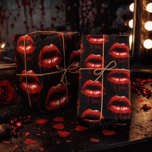 May include: Two wrapped gifts with a black background and a repeating pattern of red lips. The gifts are tied with twine. A red rose, makeup brush, and scattered red heart-shaped confetti are also visible.