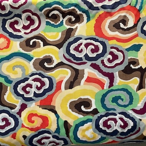 May include: A colorful fabric with a repeating pattern of swirling clouds in shades of blue, red, yellow, green, brown, and purple.