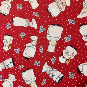 May include: Red fabric with a white polka dot pattern and a repeating pattern of cartoon chefs wearing white hats and aprons. The chefs are holding various kitchen utensils, such as a rolling pin, a wooden spoon, and a whisk.