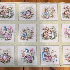 May include: A light green fabric panel featuring a repeating grid of square illustrations depicting Peter Rabbit characters in various garden scenes. The print includes soft pastel colors and the text License is re visible on the edge.