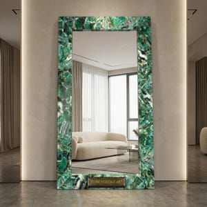 May include: A rectangular floor mirror featuring a wide frame made of polished green stone with natural crystalline patterns. A small rectangular plaque at the bottom center of the frame displays the text STONE HERITAGE ART in gold lettering.
