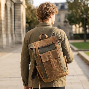 May include: A waxed canvas backpack with leather accents. The bag features a roll-top closure, adjustable straps, and multiple pockets. The color scheme includes shades of brown, green, and tan, creating a rugged, outdoorsy aesthetic.