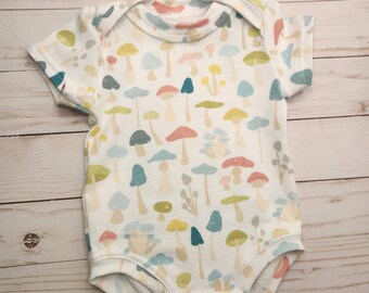 Handmade, spring mushroom bodysuit for infants made with US sourced fabric with a variety of mushrooms, short sleeve, one piece outfit, soft