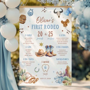May include: A decorative sign for a child's first rodeo, featuring a cowboy theme with illustrations of a cowboy hat, boots, and a steer skull. The sign includes the text "Oliver's First Rodeo" and personal details such as weight in pounds and height in inches.