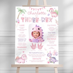 Puede incluir: Un cartel de cumplea&ntilde;os rosa y morado con el texto Charlotte is a Three-Rex, una foto de un ni&ntilde;o con disfraz de dinosaurio, ilustraciones de dinosaurios y datos personales que incluyen 9,07 kg y 63,5 cm.