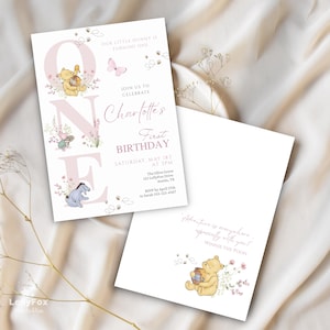 May include: Two white invitations with Winnie the Pooh theme. The front invitation has the text "Charlotte's First Birthday" with illustrations of Winnie the Pooh, Piglet, and Eeyore. The back invitation has the text "Adventure is everywhere especially with you! Winnie the Pooh."