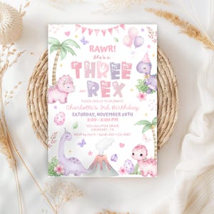 May include: A party invitation with a dinosaur theme. The invitation features the text "RAWR! She's a THREE-REX" with illustrations of dinosaurs, palm trees, and balloons. The invitation also includes the party details: date, time, and location.