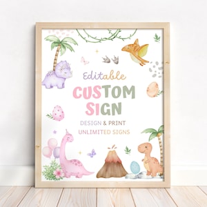 May include: A framed print featuring watercolor illustrations of dinosaurs, palm trees, and eggs. The text reads "Editable Custom Sign" in pastel colors, with "Design & Print Unlimited Signs" below. The artwork has a light wood frame and is set against a white background.