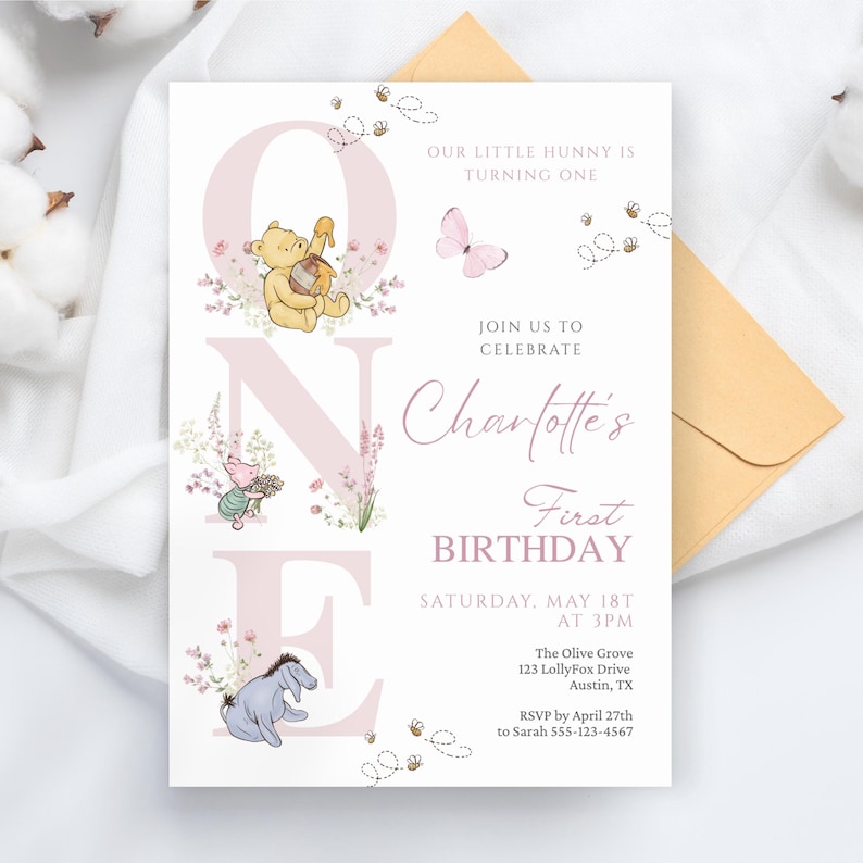 May include: A light pink and white birthday invitation featuring Winnie the Pooh characters. The invitation includes the text "OUR LITTLE HUNNY IS TURNING ONE" and "Charlotte's First Birthday". The invitation is decorated with floral and bee illustrations.