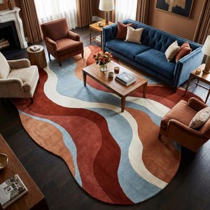May include: A living room featuring a large, wavy area rug in shades of red, blue, and cream. The rug is the focal point, complemented by a blue sofa, two armchairs, and a wooden coffee table. The room has a warm, inviting atmosphere.