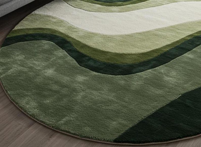 May include: A round area rug with a wave-like pattern in shades of green and off-white. The rug's design features flowing, curved lines, creating a sense of movement. The rug is made of a soft, plush material.