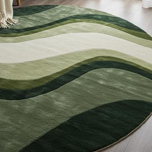 May include: A round area rug with a wave-like pattern in shades of green and white. The rug features a soft, textured surface and a beige border. The design creates a sense of depth and movement, suitable for living rooms or bedrooms.