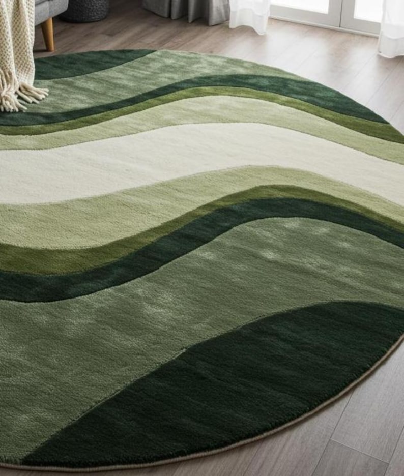 May include: A round area rug with a wave-like pattern in shades of green and white. The rug features a soft, textured surface and a beige border. The design creates a sense of depth and movement, suitable for living rooms or bedrooms.