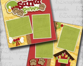 May include: A festive scrapbook layout with a red and yellow background. The layout features the text "Santa Paws" with paw prints and a Santa hat. There are green photo mats, a bone with a red bow, and a dog house with lights.