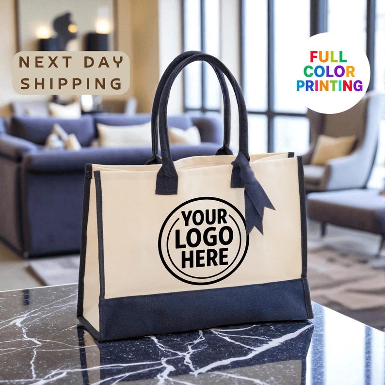 a large tote bag with a black and white design, placed on a marble countertop. The bag has a prominent logo on it, and there is text in the background that reads "Next day shipping" and "FULL COLOR PRINTING".