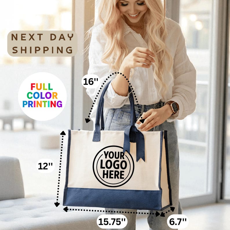 A smiling woman holding a large tote bag with a logo printed on it.