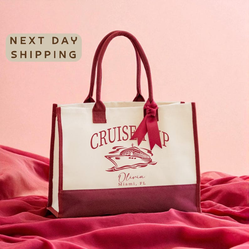 A white tote bag with a red ribbon and the text "Cruise Ship Miami" printed on it, placed on a red fabric background.